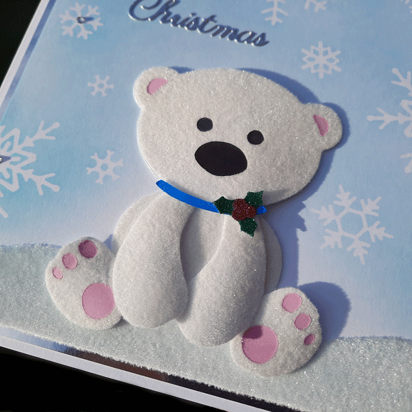 Handmade card showing a baby polar bear, made with flocking powder, sat on snow made from flock