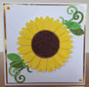 A sunflower on a handmade card, the leaves have been made with pistachio flock and spring green glitter.