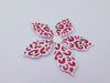 A die cut flower shape covered in Sticky Roll and partially decorated with red glitter
