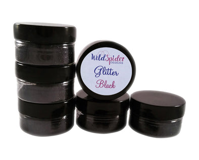 pots of Black ultra fine glitter for crafts stacked on top of one another