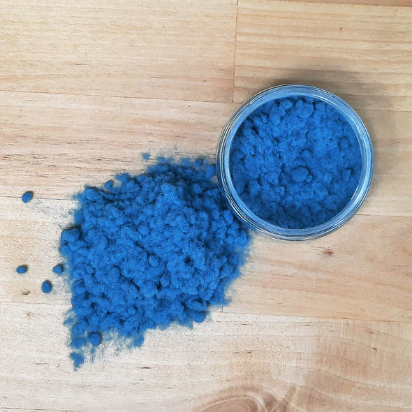 An overhead view of the Duck Egg Blue Flock for crafts, the flocking powder is poured on the table next to the pot.