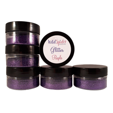 Purple glitter for crafts in pots, stacked up on each other.